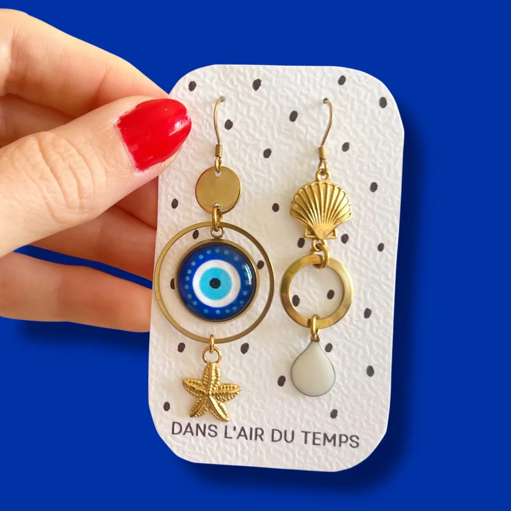 Boucles d'oreilles asymétriques oeil de turquie et coquillage finition dorée