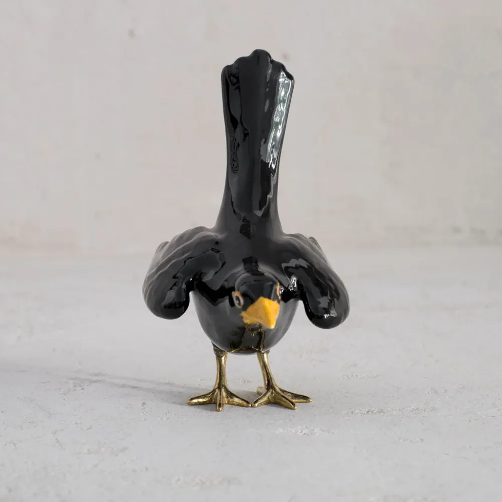 Merle avec pattes en laiton et ailes ouvertes