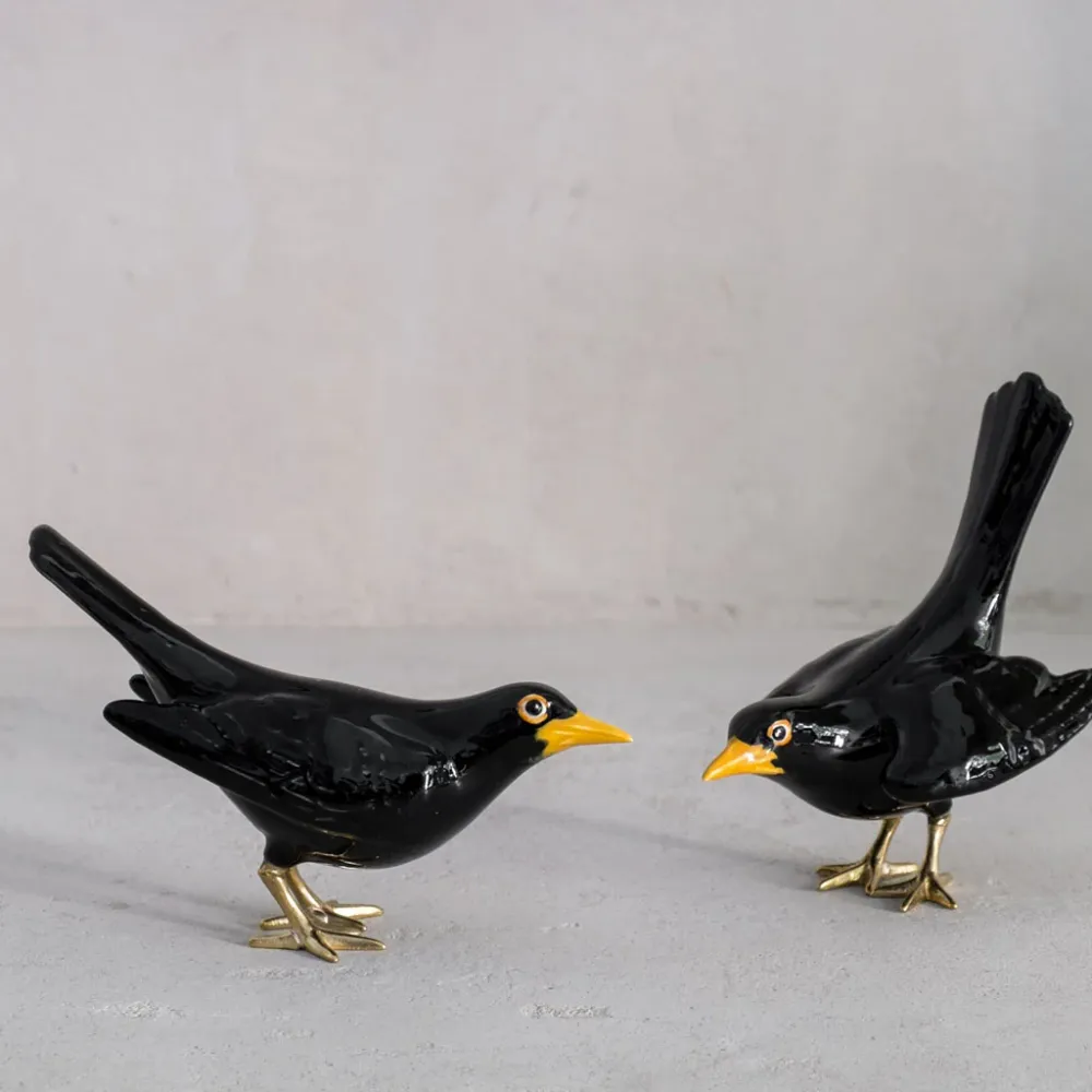 Merle avec pattes en laiton et ailes ouvertes
