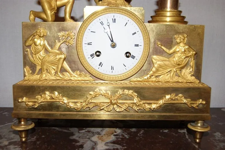 Pendule Impero à décor d'Amour et de muses en bronze doré au mercure