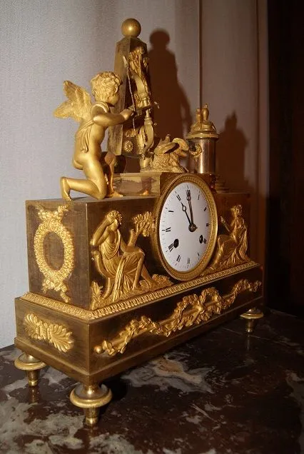 Pendule Impero à décor d'Amour et de muses en bronze doré au mercure