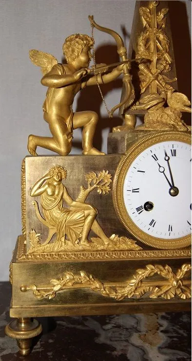 Pendule Impero à décor d'Amour et de muses en bronze doré au mercure